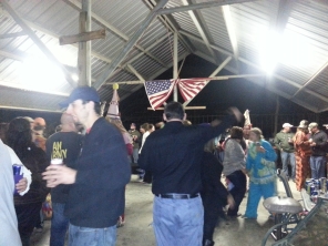 A wooden cross and an American Flag hangs from the rafters.